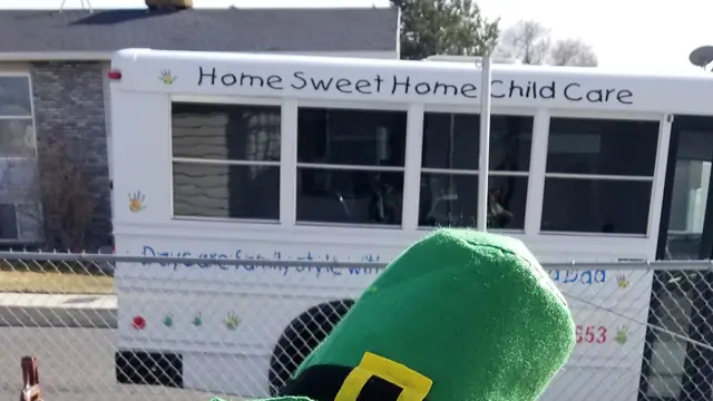 The white Home Sweet Home Child Care bus, with the name and painted handprints on the side