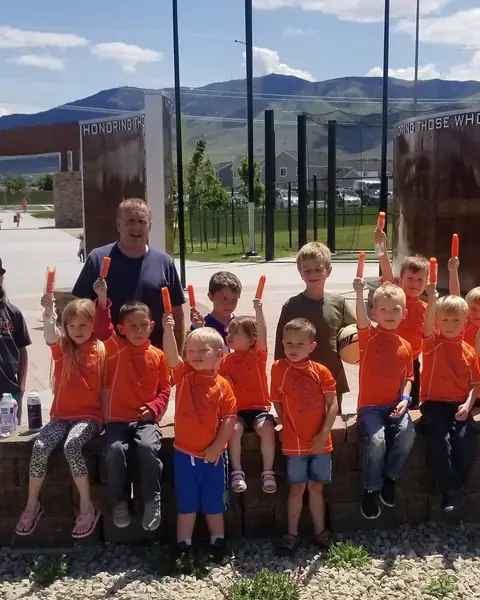 A group of children in matching orange shirts on a field trip